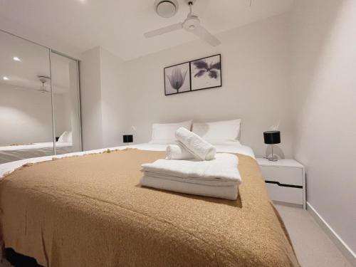 a bedroom with a bed with white sheets and a mirror at CBD RiverView 2Bed Apt Kingbed at Tallest building in Brisbane