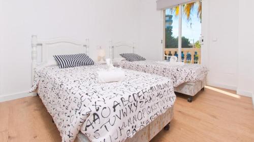 a bedroom with two beds and a window at SUN OF THE BAY in Alcudia