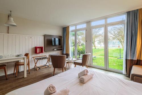 a room with a bed and a table with chairs at Studio Martin - Welkeys in Saint-Martin-de-Ré