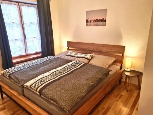 Bett in einem Zimmer mit einem großen Fenster in der Unterkunft Ferienwohnung Berglust in Sachrang