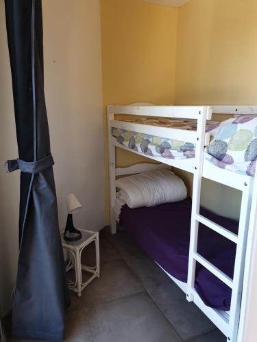 une chambre avec deux lits superposés et une lampe dans l'établissement CAPAO beau T3 vue mer piscine Cap d'Agde, au Cap d'Agde