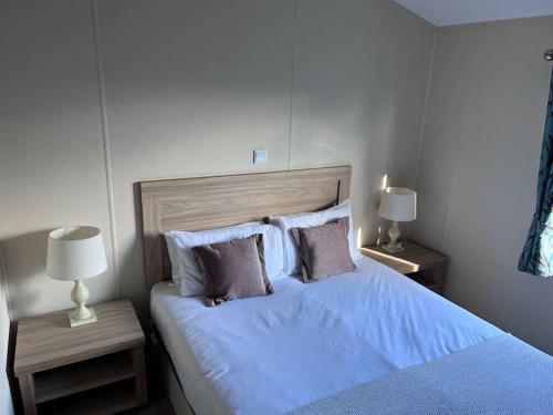 um quarto com uma cama grande com lençóis e almofadas azuis em Beautiful 2-Bedroom Lodge with Spectacular Views em Hartlepool