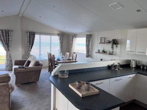 Beautiful 2-Bedroom Lodge with Spectacular Views في هارتلبول: مطبخ وغرفة معيشة مع أريكة وطاولة