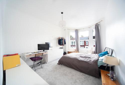 1 dormitorio con 1 cama y escritorio con ordenador en 1Bed Flat - QUIET Nest - Green Lanes en Londres