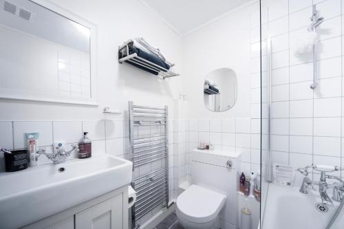 a white bathroom with a toilet and a sink at 1Bed Flat - QUIET Nest - Green Lanes in London