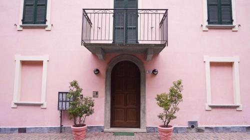 a pink building with a door and a balcony at Panoramic lake view home's Giulia in Casasco Intelvi