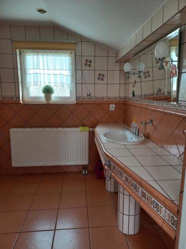 ein Bad mit einem Waschbecken und einem Spiegel in der Unterkunft U Bola in Debrzno