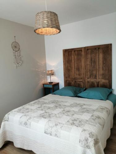 une chambre avec un grand lit avec une tête de lit en bois dans l'établissement Le passeur de Rêves, à Quend