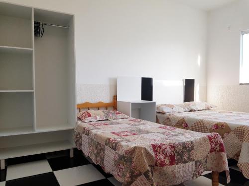 two beds in a room with two beds sidx sidx sidx at Solar Alcantara & Lazzarotto (Residencial) in Bombinhas