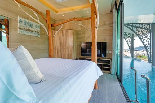 a bedroom with a bed and a balcony with a tv at Three Monkeys Villas in Patong Beach