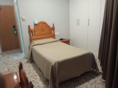 a bedroom with a bed with a wooden headboard at Hotel Estrella Del Mar in Motril