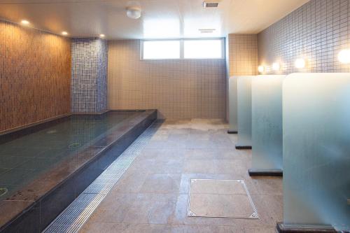 a public bathroom with stalls and ailed floor at Hotel Aston Plaza Kansai Airport in Izumi-Sano