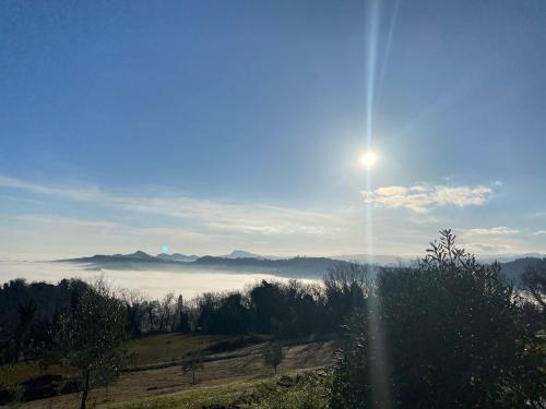 a view of a foggy valley with the sun in the sky at B&B Al Tardino in Sogliano al Rubicone