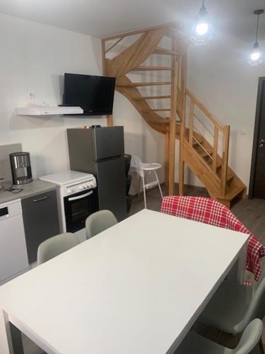 une cuisine avec une table et des chaises dans une pièce dans l'établissement La mortagne, à Rambervillers