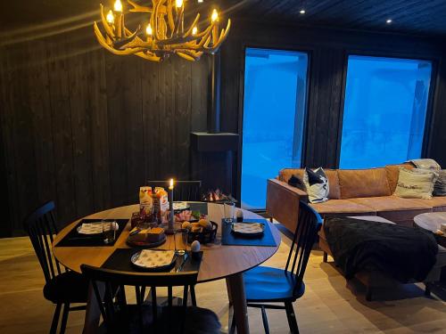 a living room with a table and a couch at Kikut Alpin Lodge - Ski In/Ski Out - Ny 2022 in Geilo