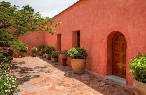 an orange building with a row of potted plants at Quinta Real Oaxaca in Oaxaca City