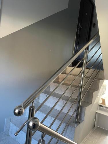a staircase with stainless steel railings and blue tiles at Sobe “Stari Grad-Samobor” in Samobor