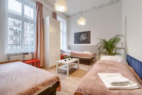 Cette petite chambre comprend deux lits et une table. dans l'établissement Kamienica Centrum Apartament nr 9, à Szczecin