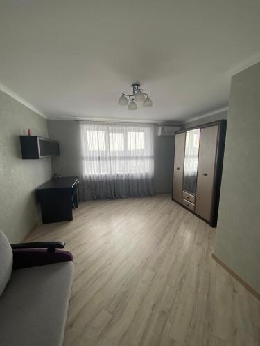 an empty living room with a couch and a hard wood floor at Apartament Vasilya Porika 48 Street Vinnitsya in Vinnytsya