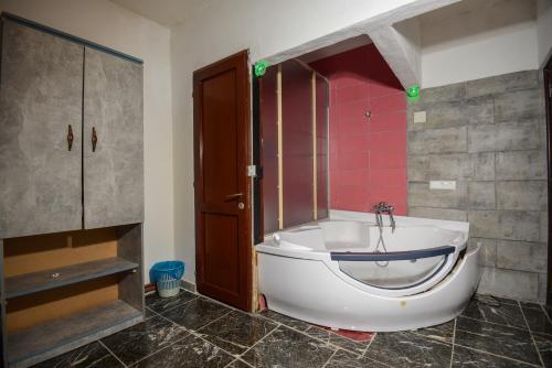 a bathroom with a bath tub and a sink at Hotel Hiking in Donja Ljuža