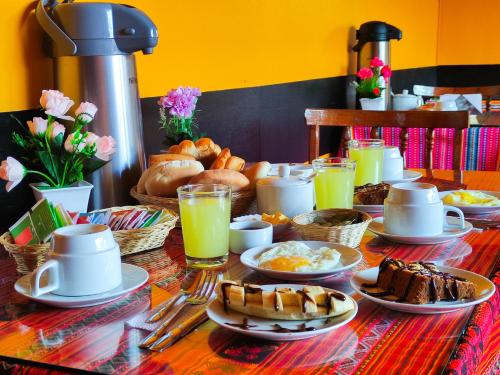 a table with breakfast foods and drinks on it at House Cusco in Cusco