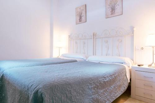 A bed or beds in a room at Apartamento con encanto en patio sevillano (202)