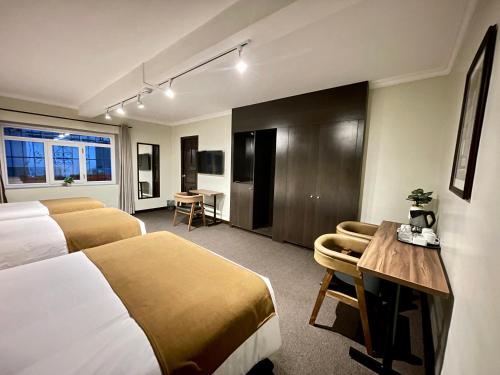 ein Hotelzimmer mit 2 Betten und einem Schreibtisch in der Unterkunft CASA MONTES PARDO in Cusco