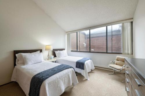 1 dormitorio con 2 camas y ventana en Two Bedroom Park Ave Condo by Lespri Property Management en Park City