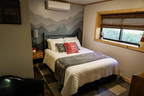 ein Schlafzimmer mit einem Bett mit einem Wandbild der Berge in der Unterkunft Cabin at the cove at Watauga Lake in Butler