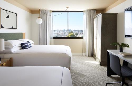 a hotel room with two beds and a desk and a window at Kimpton Hotel Enso by IHG in San Francisco
