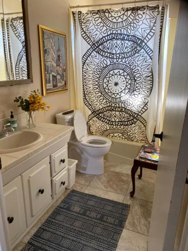 La salle de bains est pourvue de toilettes et d'un rideau de douche. dans l'établissement Desert Oasis - Joshua tree peaceful retreat Home, à Yucca Valley