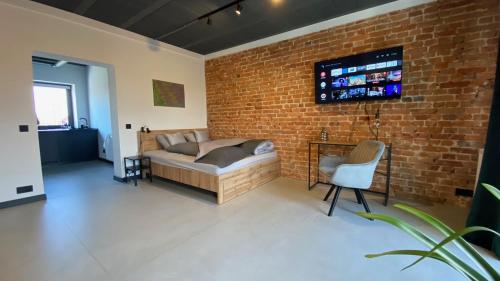 a living room with a couch and a brick wall at Apartamenty Gliwice Staromiejska 65 in Gliwice