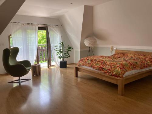 Un dormitorio con una cama y una silla y una ventana. en Spacious villa with an outdoor pool in Černošice, en Černošice