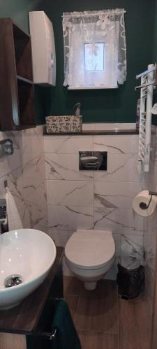 a bathroom with a white toilet and a sink at HARCÓWKA 2 in Złoty Stok