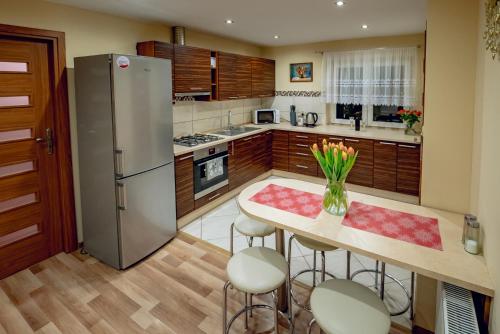 a kitchen with a table with chairs and a refrigerator at CICHY ZAKĄTEK - noclegi blisko Termy Chochołowskie in Ciche
