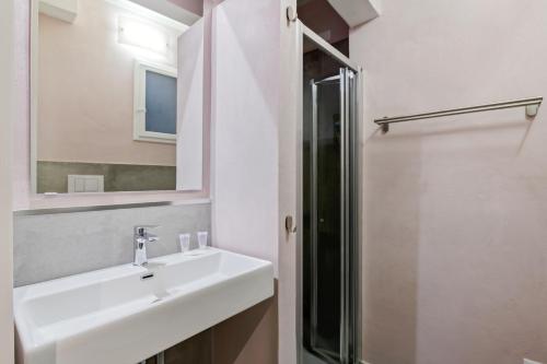 uma casa de banho com um lavatório, um chuveiro e um espelho. em Il Palazzo della Signoria Modern Loft em Florença