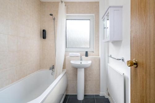 ein Badezimmer mit einem Waschbecken, einer Badewanne und einem Waschbecken in der Unterkunft Spacious Pet-Friendly Apartment in Crawley by Sublime Stays in Three Bridges