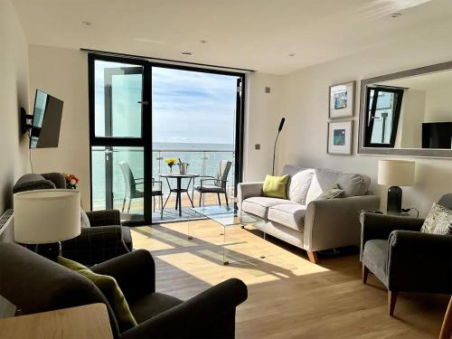 a living room with couches and a view of the ocean at SoHot Stays Royal Sands Seaview Apt Free Parking Sleeps 4 in Ramsgate