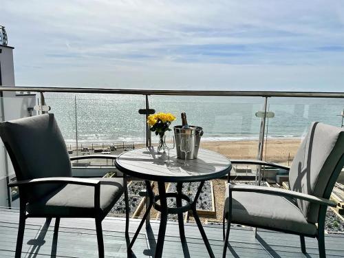 a table and chairs on a balcony with a view of the ocean at SoHot Stays Royal Sands Seaview Apt Free Parking Sleeps 4 in Ramsgate