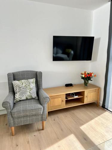 a living room with a chair and a television at SoHot Stays Royal Sands Seaview Apt Free Parking Sleeps 4 in Ramsgate