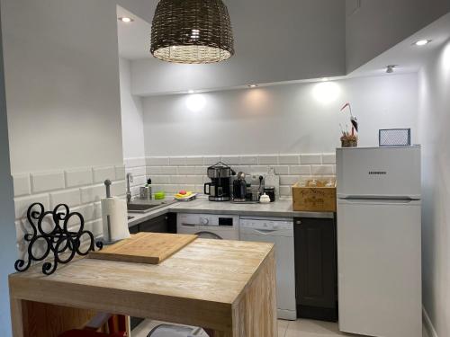 cocina con nevera y mesa. en Apartament " POD NIEBIESKIM PAGAJEM ", en Mrągowo