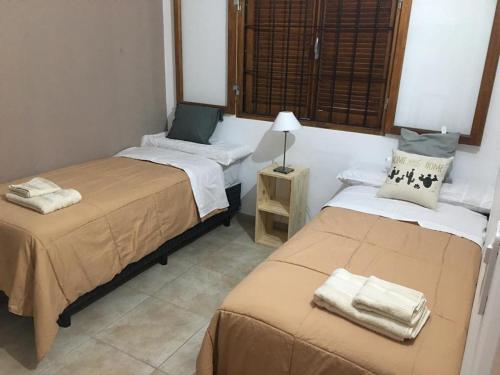 Cette chambre comprend deux lits et une table avec une lampe. dans l'établissement La Casa de Minona, à Salta