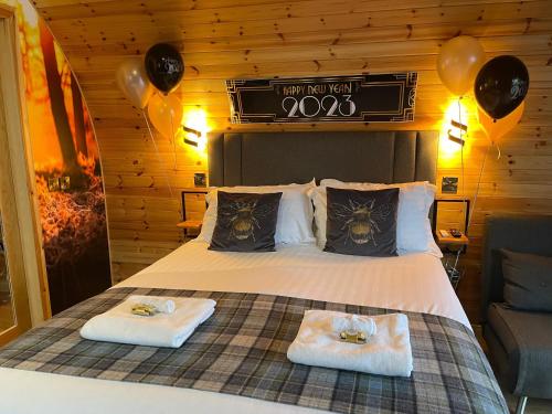 een slaapkamer met een bed met 2 handdoeken en ballonnen bij 2 Sinclair bay lodges in Keiss