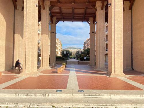 a person sitting on a bench in the middle of a building at Suite Angeli, a due passi da Assisi in Santa Maria degli Angeli
