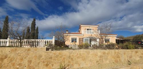 uma casa atrás de uma parede de pedra com uma cerca em Cresta Azul em Antas