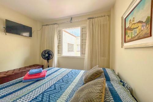 1 dormitorio con 1 cama, ventana y ventilador en Kitnet com excelente localizacao em Serra Negra SP, en Serra Negra