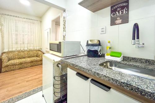 una pequeña cocina con fregadero y microondas en Kitnet com excelente localizacao em Serra Negra SP, en Serra Negra