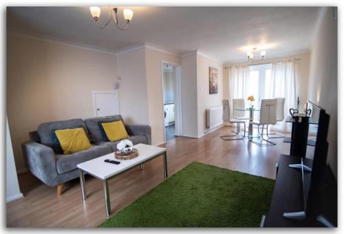 a living room with a couch and a table at BridgeCity Spacious Bartok House in the Heart of Basingstoke in Worting