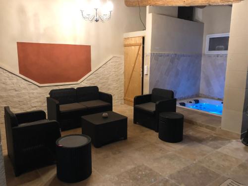 una sala de espera con sillas y una bañera de hidromasaje. en Au milieu des Piboules de Provence., en LʼIsle-sur-la-Sorgue