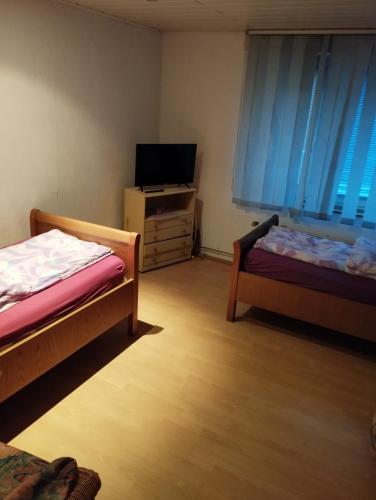 a small room with two beds and a television at worker-flat in Gelsenkirchen
